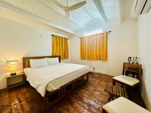 a bedroom with a large bed and a window at Cocos Beach Resort in Palolem