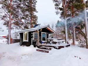 Cabaña pequeña con mesa de picnic en la nieve en Talo rantasaunalla en Vaala