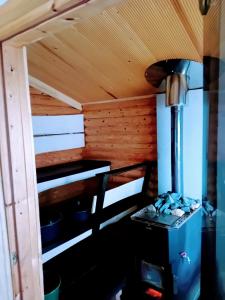 una estufa en una cabaña con techo de madera en Talo rantasaunalla en Vaala