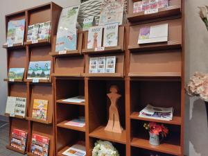 ein Bücherregal mit Büchern und einer Puppe in der Unterkunft New Grand Hotel in Shinjo