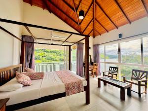 a bedroom with a bed and a large window at Villa Victoria Edge in Digana