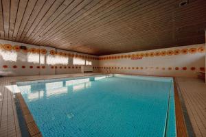 a large swimming pool in a building with a wooden ceiling at Apartment Frida in Flachau