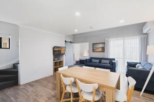 a dining room and living room with a table and chairs at Amalfi Resort in Busselton