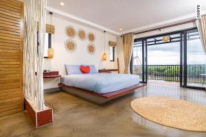 a bedroom with a bed and a balcony at Santaniya Residence in Kampot