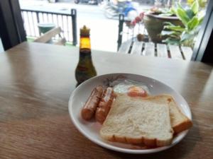 - une assiette de nourriture avec du pain grillé et une bouteille de bière dans l'établissement YOWGO THAI Guesthouse 青年旅館, à Bangkok