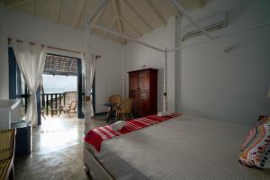 ein Schlafzimmer mit einem großen Bett und einem Balkon in der Unterkunft Poya Villa Ahangama by Sunsessions in Ahangama