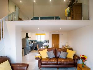 a living room with a brown leather couch at Parshalls Retreat in Broadway