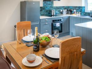 a kitchen with a wooden table with a bottle of wine at Parshalls Retreat in Broadway