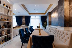 a restaurant with a long table and blue chairs at Hotel NOBLESSE Boutique&Spa in Râmnicu Vâlcea