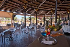 a restaurant with tables and chairs and fruit on a table at Fuengirola Beach Apartamentos Turísticos in Fuengirola