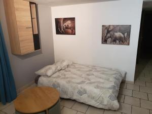 a bedroom with a bed and two pictures on the wall at Appartement T2 chez Seb et Claire in La Bâthie
