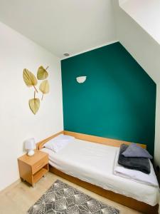 een slaapkamer met een groene muur en een bed bij HOTEL MILO - Noclegi Bartoszyce in Bartoszyce