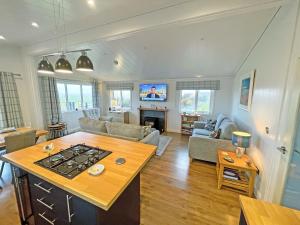 a kitchen and living room with a stove at Kilda View in Berneray