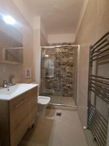 ein Bad mit einer Dusche, einem Waschbecken und einem WC in der Unterkunft Ellis Apartments in Thessaloniki