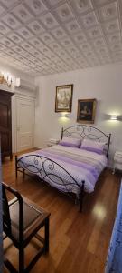 una camera da letto con un grande letto con cuscini viola di 3B Locazione Turistica a Mestre