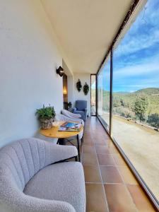 a living room with chairs and a table and a balcony at Casa Migjorn in Valls de Torroella