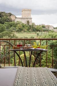 uma mesa numa varanda com vista para um castelo em La Gustea Hotel & Cucina em Sarteano