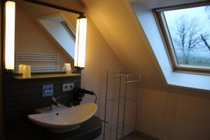 baño con lavabo, espejo y ventana en Gasthaus Zur Riete en Celle