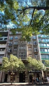 un grand bâtiment avec des personnes debout devant lui dans l'établissement Authentic Belgrade Centre Apartments, à Belgrade