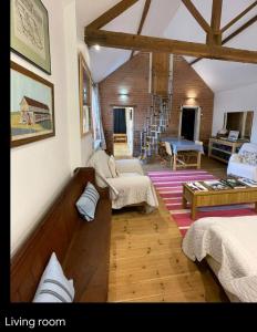 a living room with two beds and a staircase at 300 year old barn conversion in Retford