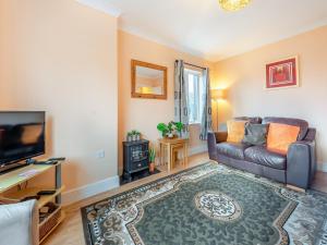 a living room with a couch and a television at Ffynnon Dewi - Uk45909 in Landshipping