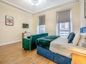 a bedroom with a large bed and a chair at Apartment One - Uk44284 in Arbroath