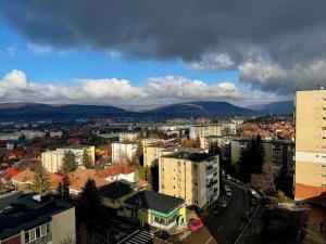 a city with buildings and mountains in the background at Panoramic Apartment in Odorheiu Secuiesc