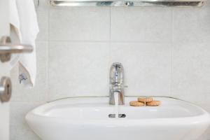 a bathroom sink with a faucet and two cookies on it at Acteon Hotel in Ios Chora