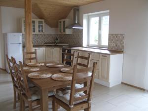 una cucina con tavolo in legno, sedie e frigorifero di Apartment Sendraž a Sendraž