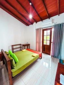 a bedroom with a large bed with green pillows at Hotel Grand Resto in Katugastota +35 photos