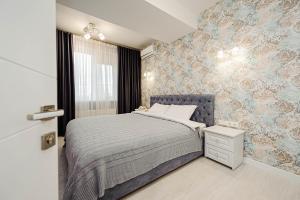 a bedroom with a bed and a wall with wallpaper at Elegant escape in Chisinau! in Chişinău