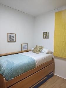 1 dormitorio con cama y cortina amarilla en TURQUESA CENTRO, en Soria
