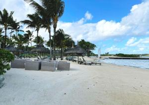 a beach with chairs and umbrellas on the beach at Private Beach 5-star Villa, Golf & Luxe in Centre de Flacq