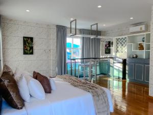 sypialnia z białym łóżkiem i kuchnią w obiekcie NanaH Tha Phae Private House w mieście Chiang Mai