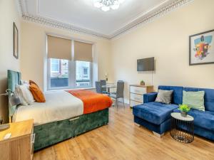 1 dormitorio con 1 cama y 1 sofá azul en Apartment Two - Uk44285, en Arbroath