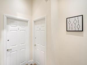 a white hallway with two white doors and a picture at Apartment Two - Uk44285 in Arbroath