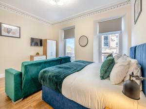 a bedroom with a green bed and a window at Apartment Three - Uk44286 in Arbroath