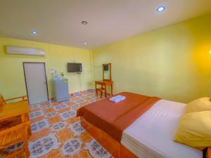 a bedroom with a bed and a tv in it at โชติอนุสรณ์ รีสอร์ท ชุมพร in Ban Bang Mak (1) +3 photos