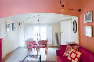 - un salon avec un canapé rouge et une table dans l'établissement Lussuoso Appartamento nel Cuore del Centro Storico, à Bologne
