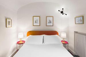 - une chambre avec un grand lit blanc et deux tables de chevet dans l'établissement Lussuoso Appartamento nel Cuore del Centro Storico, à Bologne