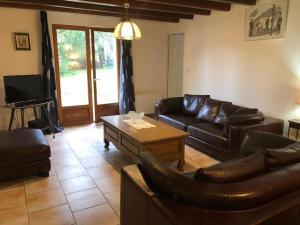 a living room with leather couches and a coffee table at De brique & de bois, Lac du Der in Louze