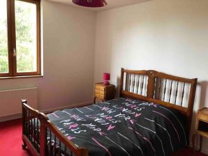 a bedroom with a bed with pink flowers on it at De brique & de bois, Lac du Der in Louze