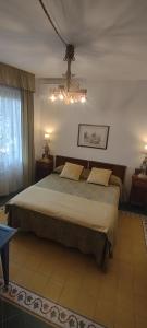 ローマにあるRelais La Canforaのベッドルーム1室(ベッド1台、シャンデリア付)