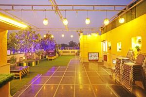 un patio extérieur avec des chaises, des tables et des lumières dans l'établissement JRD Luxury, à New Delhi