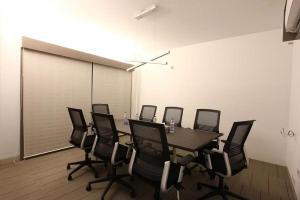 a conference room with a table and black chairs at Spring Hill Hotel & Apartments in Dhaka