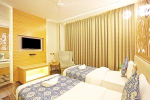 a hotel room with two beds and a television at JRD Luxury in New Delhi