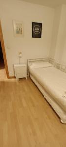 a bedroom with two beds and a night stand at En el pleno centro de Biescas con garaje, ascensor y WiFi in Biescas +19 photos
