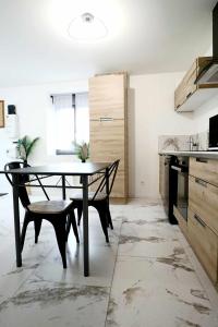a kitchen with a table and chairs in a room at Appartement Le Moderne Idéal pour Couples et Professionnels in Ornans