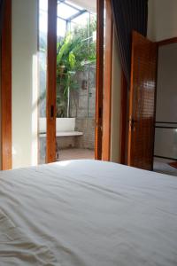 1 dormitorio con cama blanca y ventana en Bromo Venture, en Probolinggo