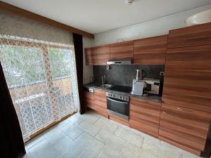 una cucina con armadi in legno e una grande finestra di Austrian Motel Heiss a Prutz